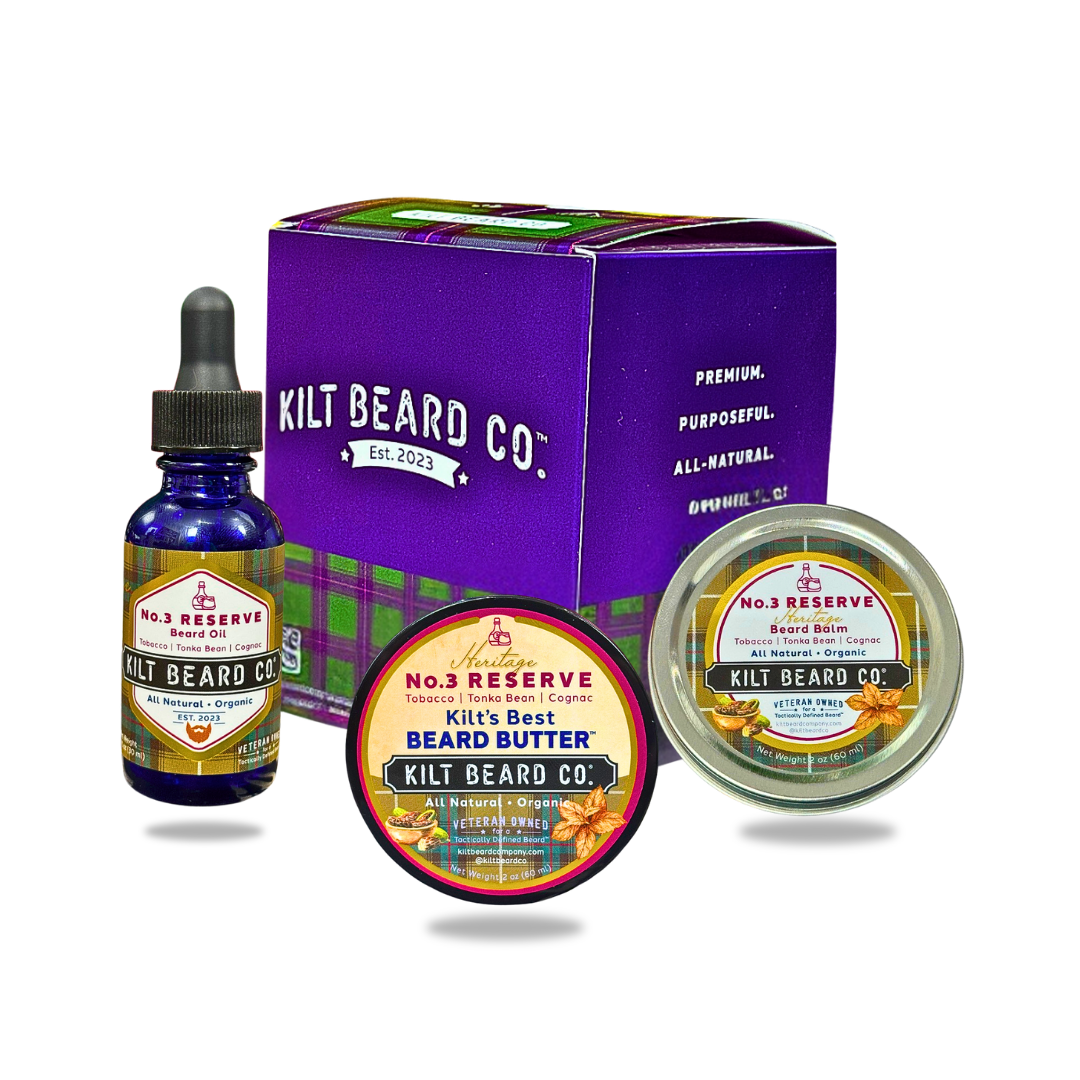 Kilt Beard Co. beard care set including a purple branded box, a blue glass dropper bottle of beard oil, a round tin of beard balm, and a round jar of beard butter, arranged on a white background. No.3 Reserve, tobacco, cognac, tonka bean, and oakmoss scent.